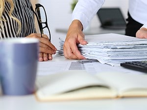 Two people sorting through tax paperwork